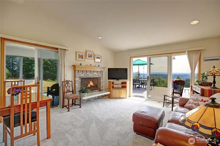 Living room off the kitchen with wood burning fireplace, french doors to large deck and access to sun room.