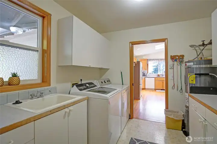 Ideal laundry room with ample storage and utility sink!
