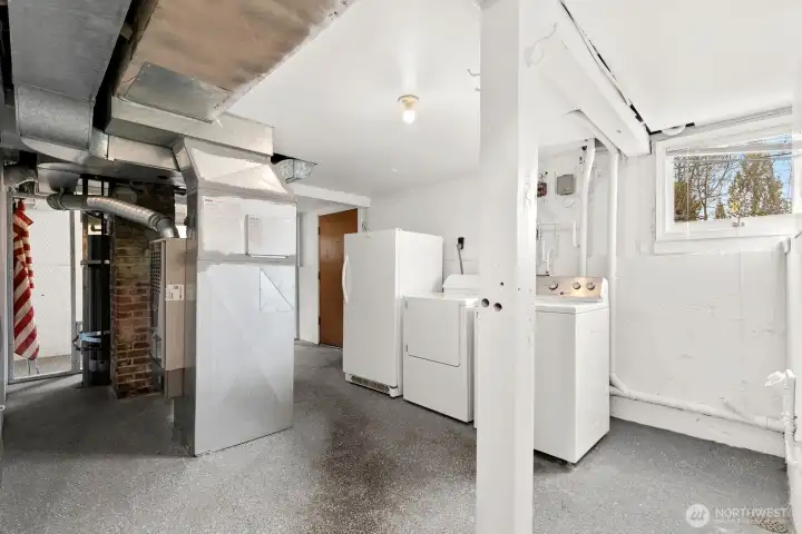 Laundry and storage space with newer gas furnace