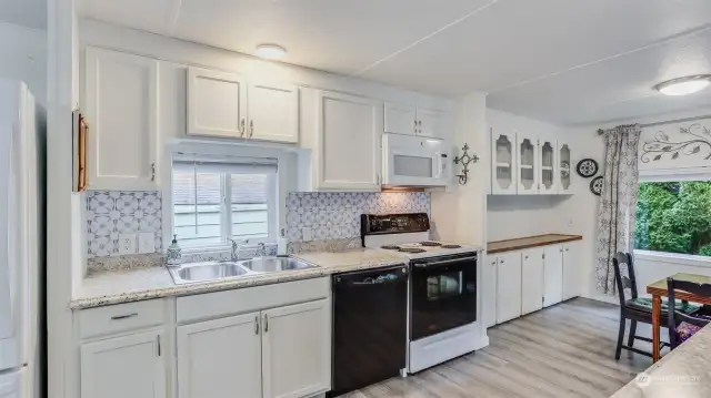 You will love meal time and hosting in this open kitchen with white cabinets, big windows providing ample natural light and two dining spaces.