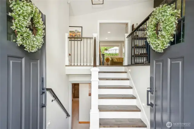 Hardwood floors throughout entry, stairs, living room, family room, and hallway.
