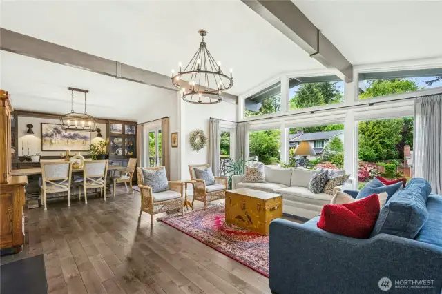 Spacious living room with large west-facing windows, custom drapes, and remote-controlled plantation blinds.