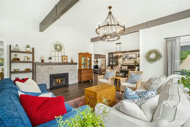 Spacious living room with large west-facing windows, custom drapes, and remote-controlled plantation blinds.