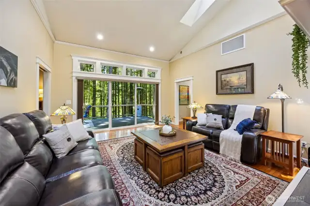 Main Home - Living room with large open windows leading to the deck with territorial views of the backwoods and Deschutes River.