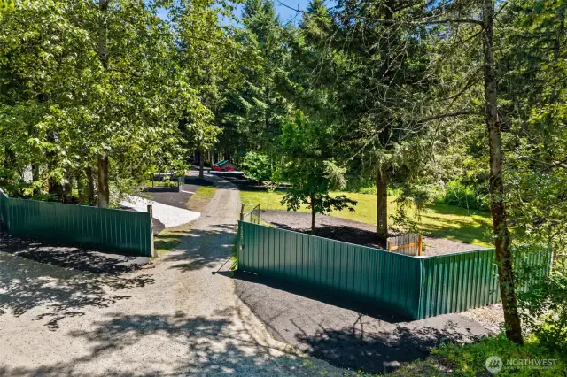 Front gated entryway of property with electric gate opener. Both homes are nestled in the trees in a parklike setting. WOW!