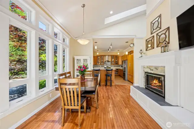 Main Home - Dining area with fireplace leading to kitchen.