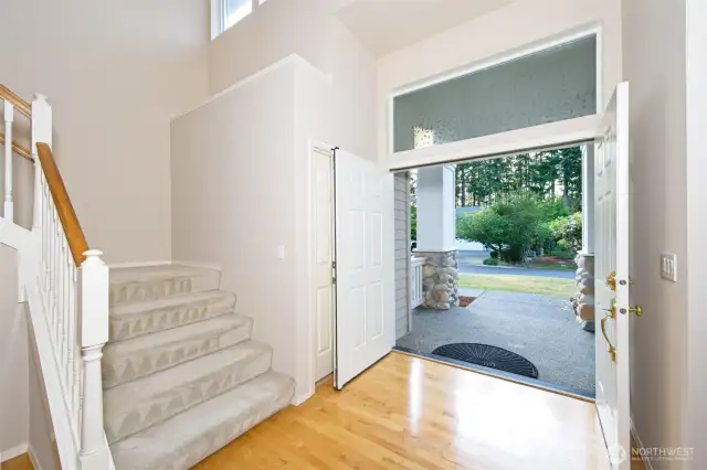 Entryway with double front door and maple hardwood floors.