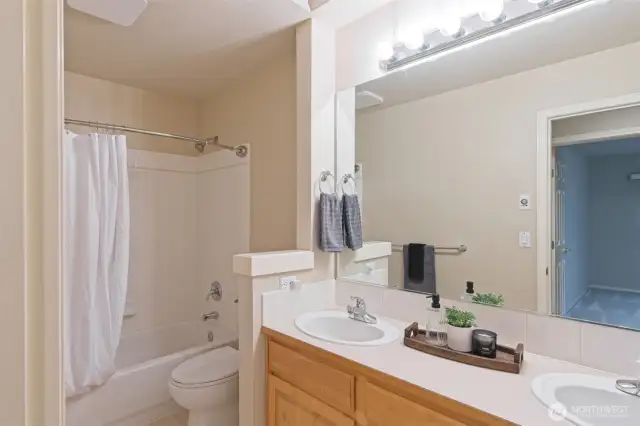 Full bath on the second floor with maple cabinets and double sinks.
