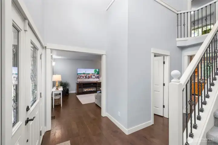 Welcoming entry with hardwood floors and open flow to the main living spaces. Staircase leads to the upper level, creating a bright and spacious feel.