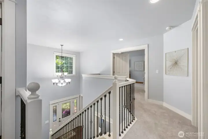 Open to the foyer below with stylish black-accented stair railings.