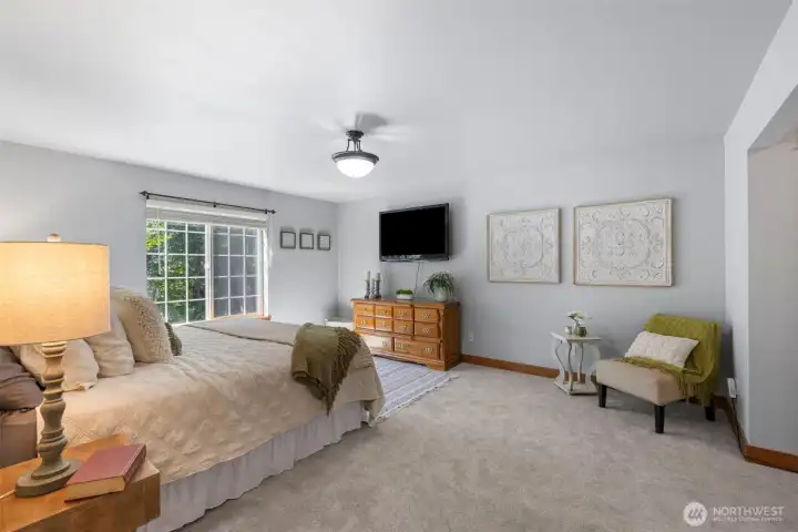 Spacious and serene primary suite with plenty of natural light, ensuite bath, and room for a king-size bed and additional furniture.