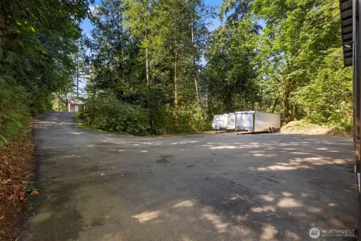 Expansive paved parking area provides room for multiple vehicles, trailers, and RVs—ideal for guests, equipment, or work trucks.