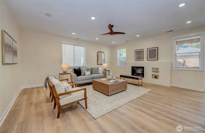 Family room with electric fireplace and windows overlooking the yard