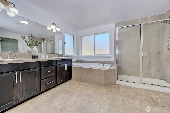 Primary bathroom with separate tub, two sinks, shower, toilet room, & walk-in closet