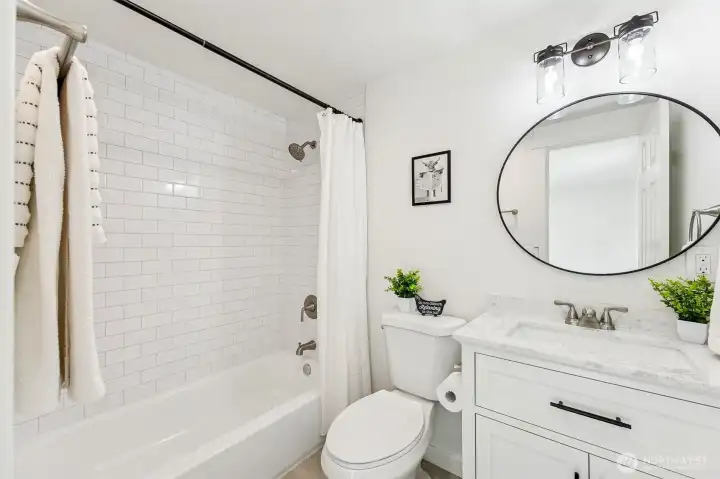 Fully renovated bath with modern fixtures, stylish tilework, and clean lines.