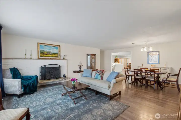 Light filled living room featuring cozy fireplace and timeless hardwoods.