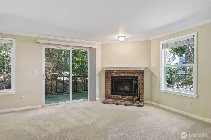 Living room with wood burning fireplace and sliding glass doors to patio.