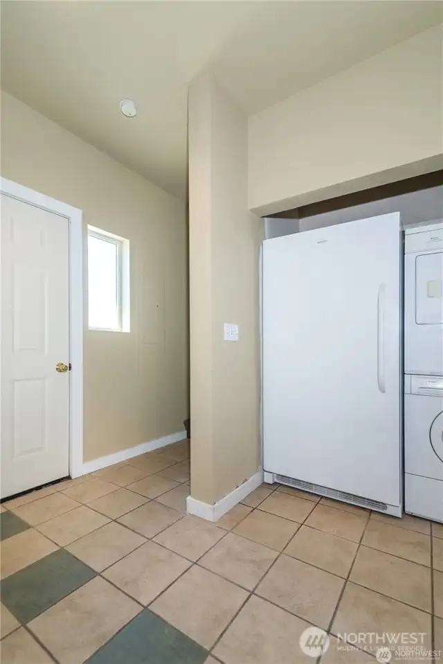 Washer, dryer and 2 extra refrigerators. There are stairs leading to the second level and another side door. Plus a entry door to the right to the garage.