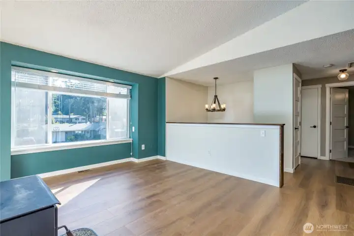 Bright living room with large window overlooking the front yard