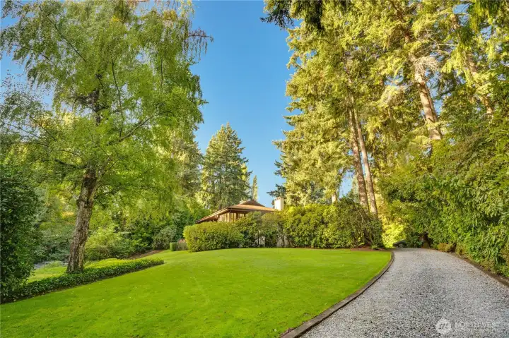 Rolling lawn down to Chambers Creek as you approach the home.