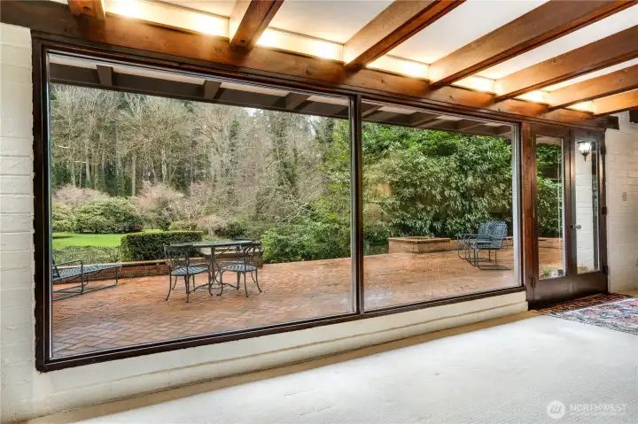 Across from the fireplace in the living room is a wall of windows with french doors leading to the rear patio with built in planters & seating.