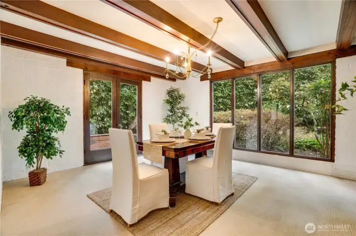 Dining room with green views outside punctuated with a gold crystal chandelier.