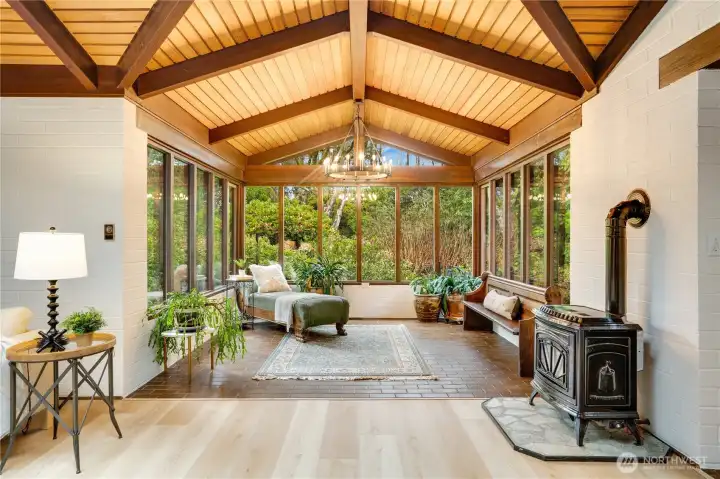 Still in the rec room is a sun room seating area with freestanding gas fireplace.