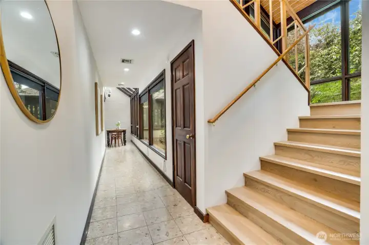 Staircase off the main entry with hallway leading to the kitchen.