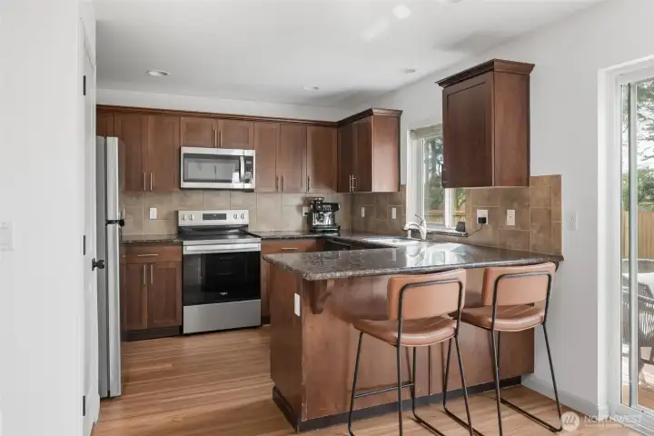 Light and bright kitchen with granite counters & breakfast bar