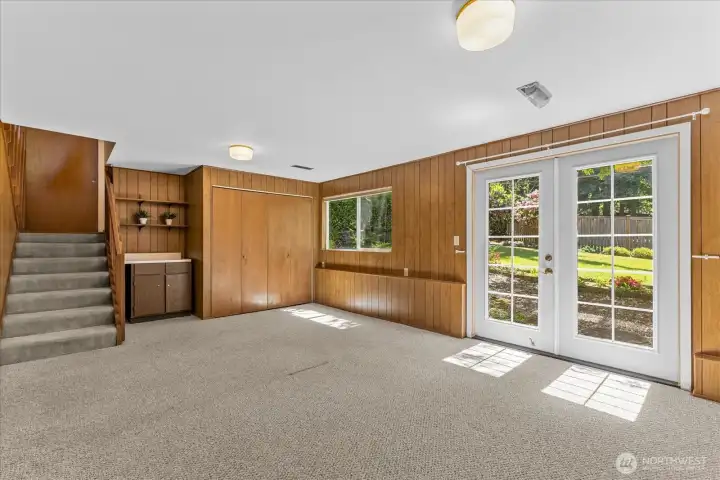 Flexible lower-level space with French doors to the backyard, a cozy bar area and conveniently hidden laundry area behind closet doors Flexible lower-level space with French doors to the backyard, a cozy bar area and conveniently hidden laundry area behind closet doors