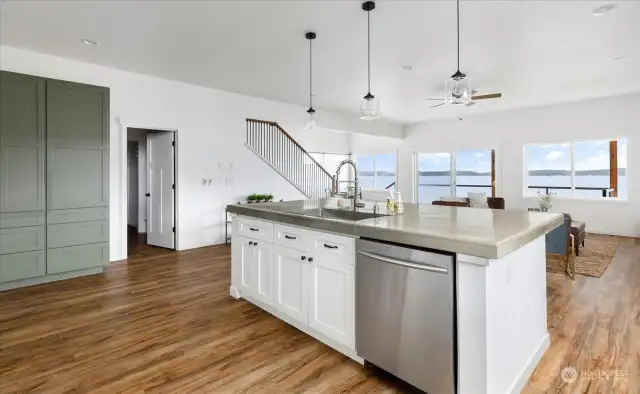 The open concept kitchen is adorned with a polished concrete counter top. To the left is door leading into laundry room.