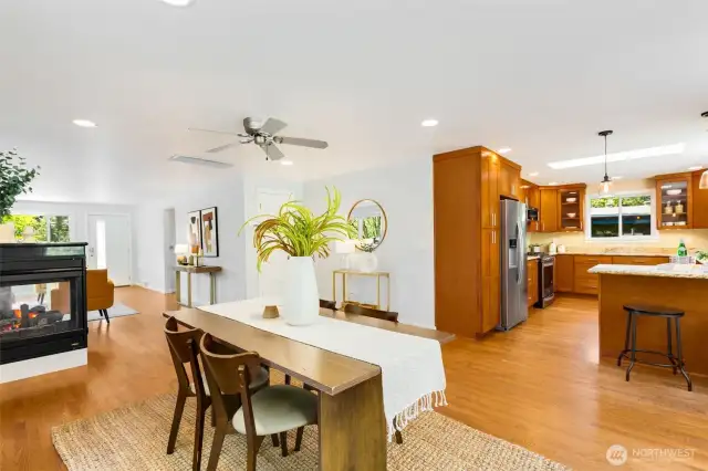 Love the connection between dining room  and kitchen. Cozy 2-sided gas fireplace  anchors the space.