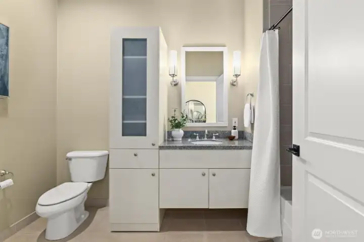 Full bathroom on the main level with a clean modern look and cozy soaking tub.
