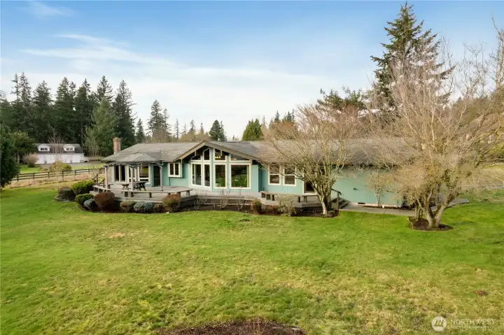 Front of home features a large entertainment deck with built-in benches, perfectly positioned to enjoy the  mountain view.