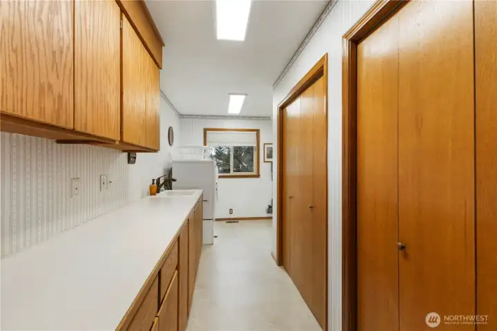 Laundry room with storage closets, cabinets and folding counter surface.