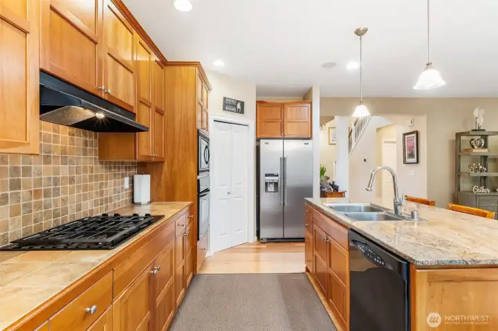 Cherry cabinets, gas cooktop, wall oven with microwave above, walk-in pantry, and large island are the ingredients for some fabulous feasts.