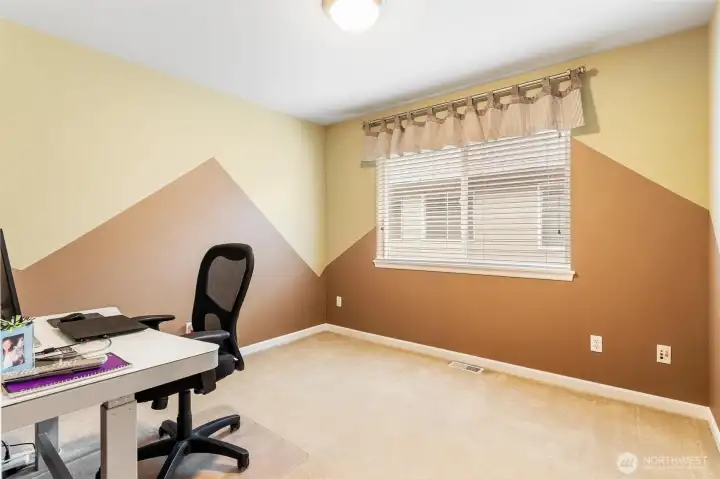Bedroom with a custom mountain theme is used as a secondary office.