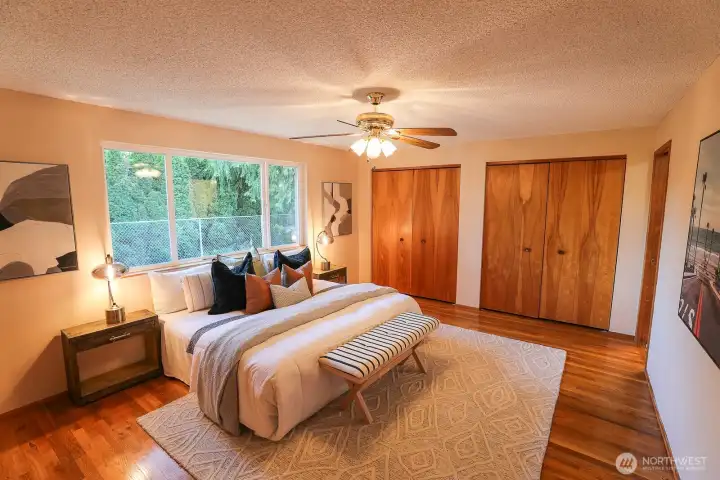 primary bedroom with large picture frame window of private side yard