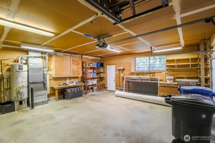 spacious two car garage with lots of built in storage and workspaces