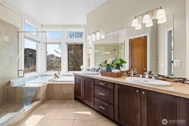 Beautifully appointed Primary Bathroom features Dual Sinks, Soaking Tub, Oversized Shower with Glass Doors, Heated Tile Flooring, and a separate toilet room.