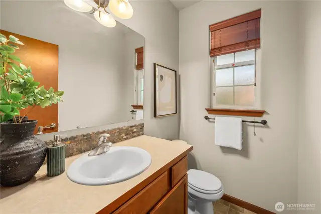 Main-floor half bath with beautiful stone tile backsplash