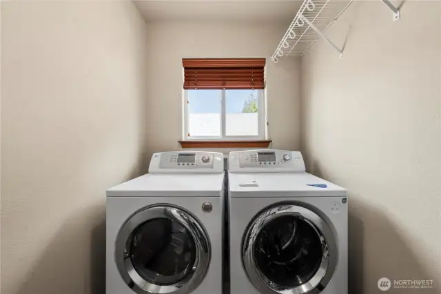 The upstairs laundry room comes with front-loading washer and dryer and features upper cabinets and a folding counter