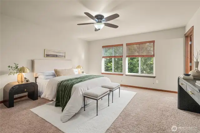 Spacious primary bedroom with ceiling fan and plenty of room for a King-sized bed.