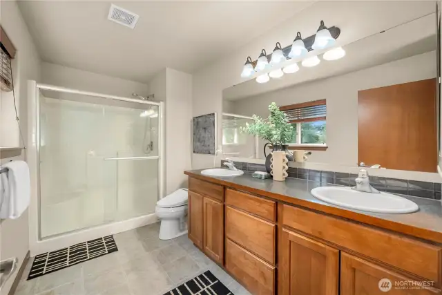 The primary bathroom features a 5' shower and a dual-sink vanity.