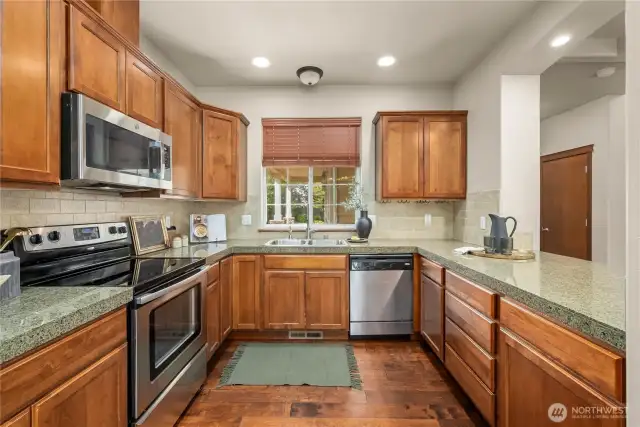The kitchen is appointed with cherry cabinets, crown moulding, instant hot water faucet, and full-height tile backsplash