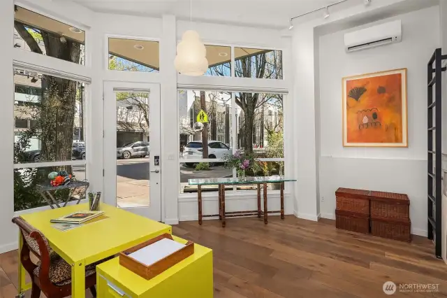 Welcoming natural light and twelve-foot ceilings greet the visitor at entry level ground floor. The prime corner position grants a meaningful street presence for retail or business use.  Note transom windows above and over windows and door.