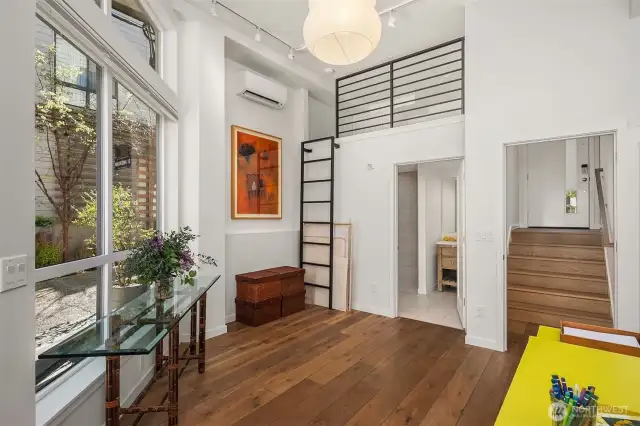You have entered the commercial space.  Wide plank oak flooring, high twelve-foot ceilings to accommodate loft that can be used for storage or sleep.  The stairs to the right lead up to the back door of the townhouse.  The two separate entrances can allow for separate use of commercial and living spaces and/or leasing either one individually from the other.