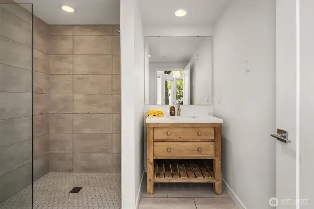 Stunning three-quarter bath in commercial space. Level entry to the porcelain tiled shower. Handcrafted sink.