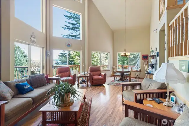 Dining and living areas share an open layout, providing flexible space for gatherings. The large windows fill the space with natural light.
