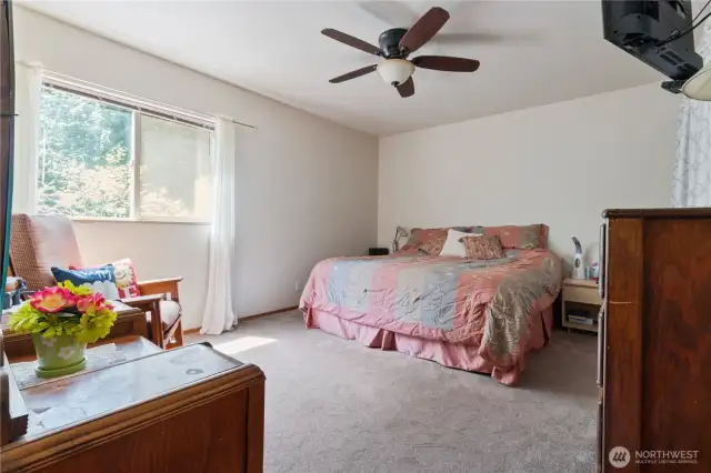 Primary suite on the main level is set apart from the kitchen, dining, and living areas for quiet and seclusion.
